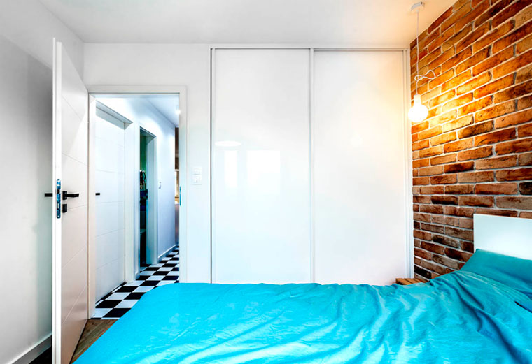 Маленькая спальня со встроенными шкафами со стороны двери – фото